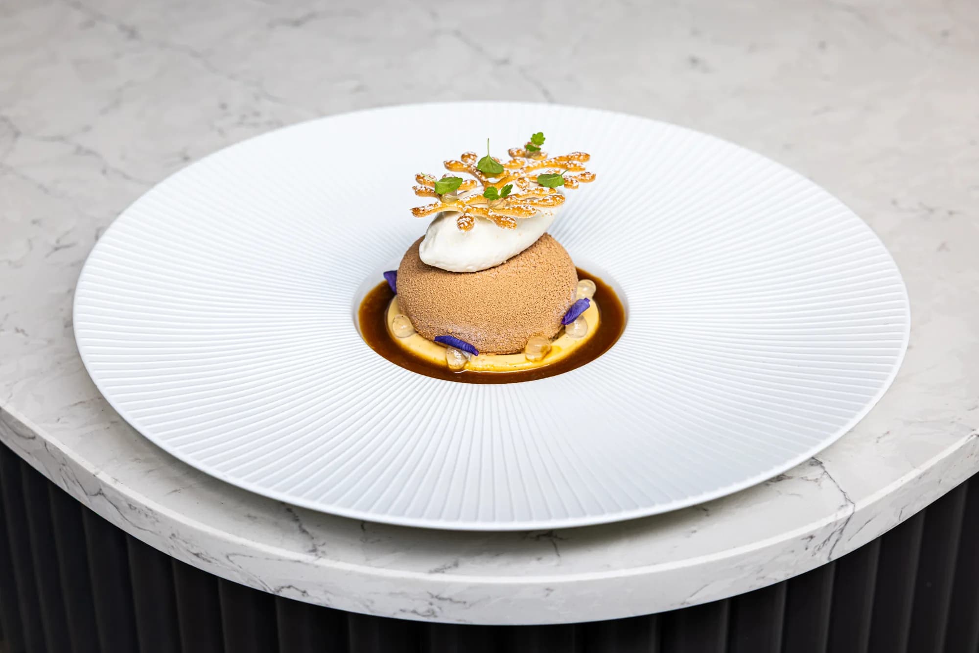 Feestelijk dessert: bol mousse met crème en een krokante garnering