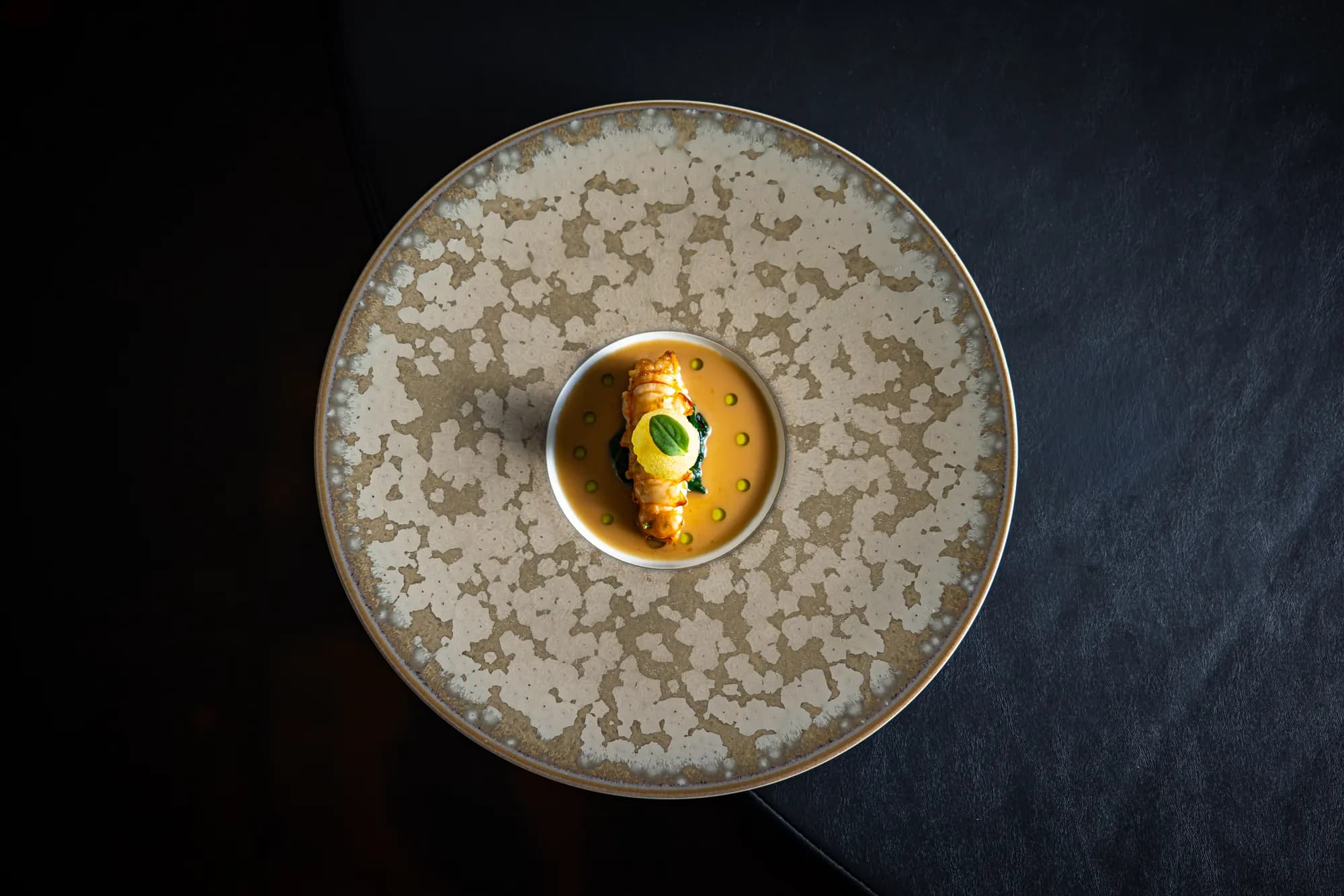 Langoustine op spinazie in een goudgele saus, van boven gefotografeerd