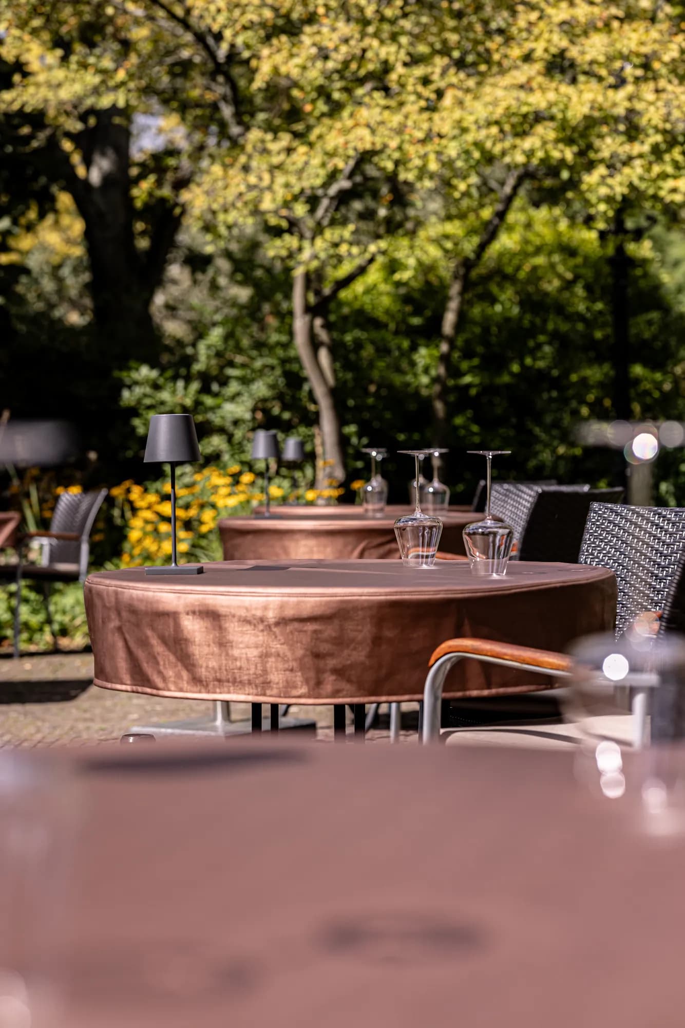 Gedekte tafels op het tuinterras, omringd door groen