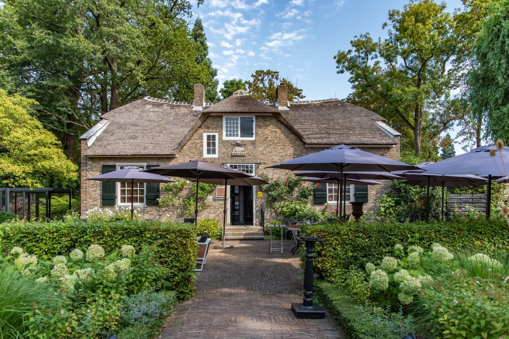 Het rieten dak en de historische gevel van In Den Rustwat